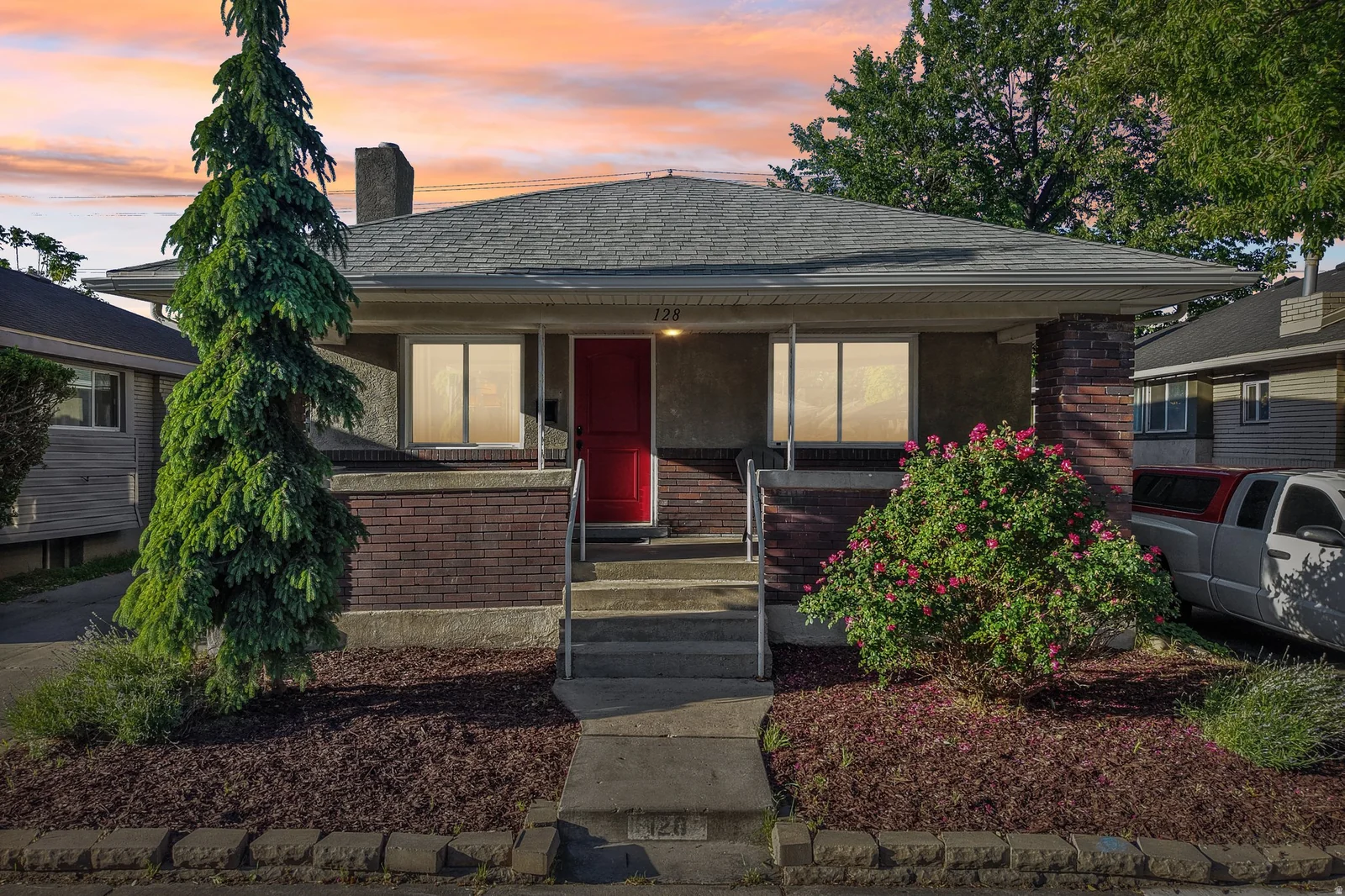 Charming single-story residence featuring a prominent red entry door and a covered front porch
